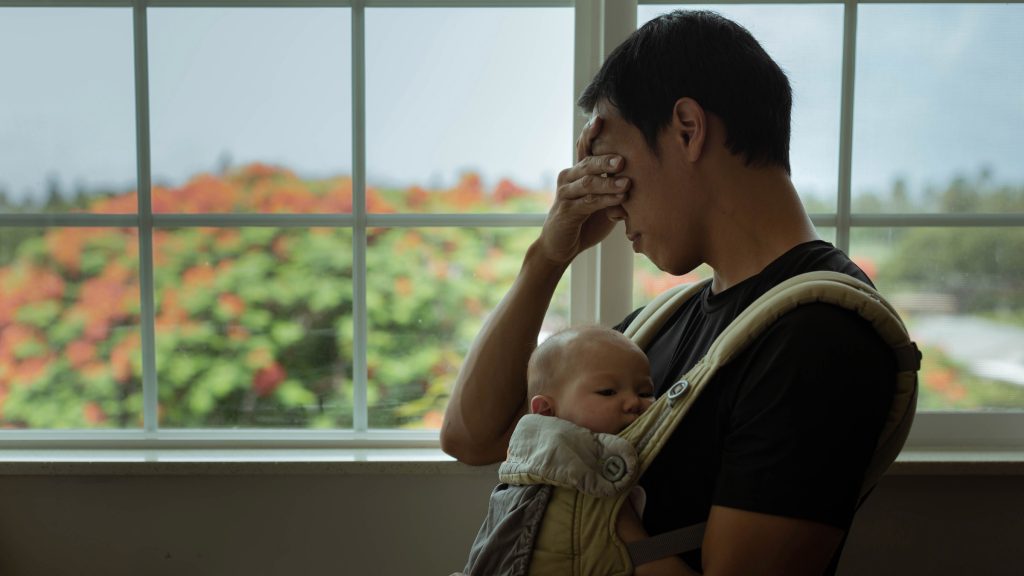 Father at desk, head in hands, stressed